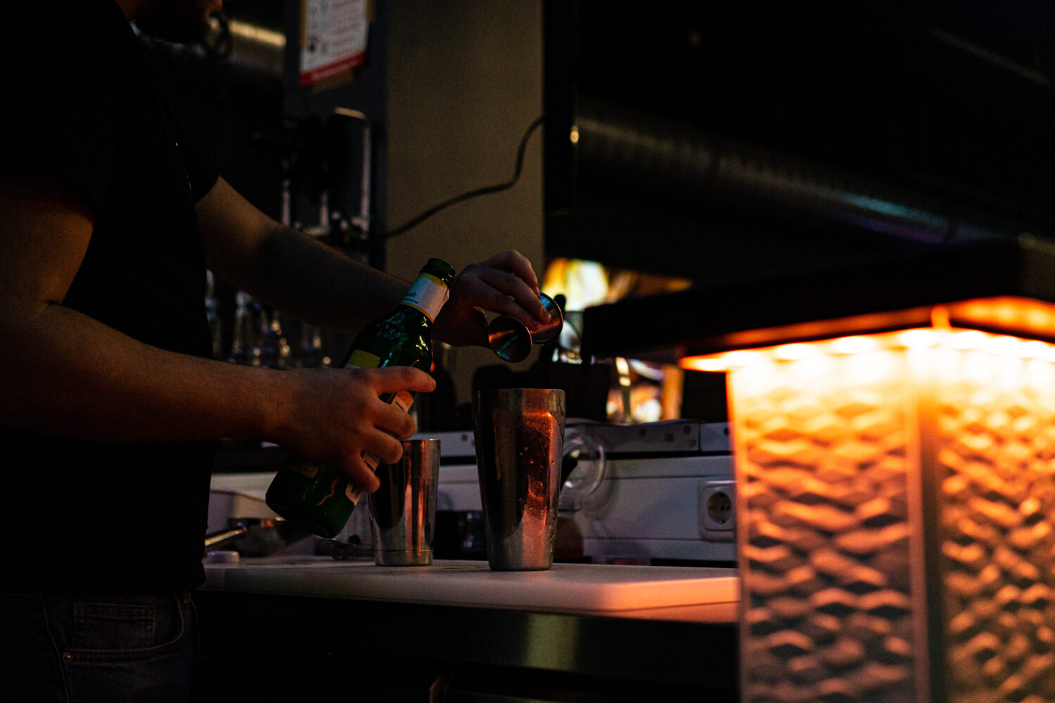 Barkeeper mixt einen Cocktail bei warmem Licht